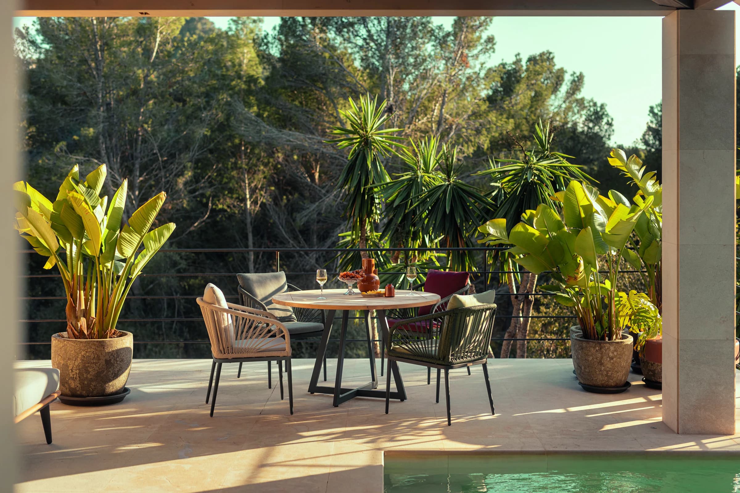 Überdachte Terrasse mit Esstisch und Outdoor-Sesseln